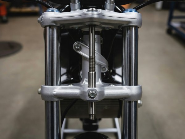 Front headstock stand pin inserted upward into the lower triple clamp steering stem hole